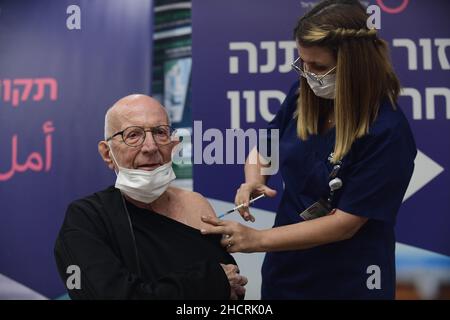 Ramat Gan, Israele. 31st Dic 2021. (211231) -- RAMAT GAN (ISRAELE), 31 dicembre 2021 (Xinhua) -- Un uomo riceve la sua quarta dose del vaccino COVID-19 presso lo Sheba Medical Center di Ramat Gan, Israele centrale, il 31 dicembre 2021. Il Ministero della Sanità israeliano ha dichiarato di aver approvato la somministrazione del quarto vaccino di richiamo sparato contro COVID-19 per i residenti e il personale delle case di cura. (Tomer Neuberg/JINI via Xinhua) Credit: Xinhua/Alamy Live News Foto Stock