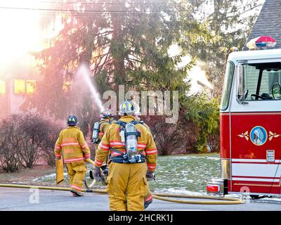 Vigile del fuoco al fuoco di lavoro con fiamme drammatiche Foto Stock