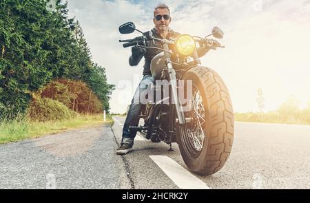 parcheggio per motociclisti sul lato destro della strada e al tramonto. pronto per un viaggio in moto. Foto Stock