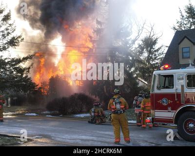 Vigile del fuoco al fuoco di lavoro con fiamme drammatiche Foto Stock