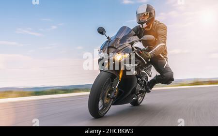guida in moto in curva. guida su strada vuota in moto. copyspace per il tuo testo individuale. Foto Stock