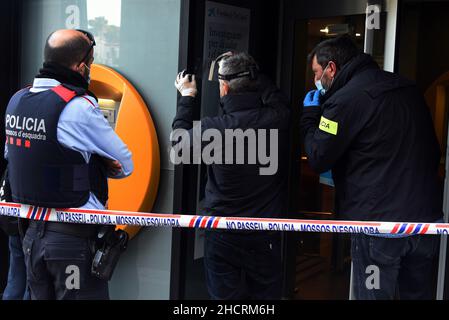 Vendrell, Spagna. 31st Dic 2021. Due agenti del Catalan Police Theft Investigation Group cercano le impronte digitali del rapinatore della banca Caixabank entity.A uomo con un coltello effettua una rapina in un ufficio della banca CaixaBank a El Vendrell (Tarragona Spagna) in fuga con una raccolta ancora da determinare da parte dei responsabili della banca. La polizia catalana indaga sulla scena della rapina e cerca le impronte digitali del rapinatore (Foto di Ramon Costa/SOPA Images/Sipa USA) credito: Sipa USA/Alamy Live News Foto Stock