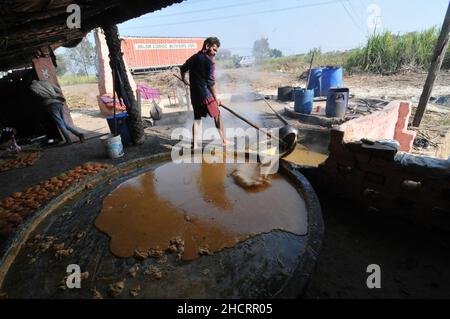 New Delhi, India. 31st Dic 2021. Gli agricoltori di un mulino per lo zucchero, alla periferia della capitale di Nuova Delhi processo la gelificazione, che è di zucchero di canna tradizionale con un colore marrone che si consuma nel subcontinente indiano e sud-est asiatico. Il 31 dicembre 2021 a Khatoli, India. (Foto di Ravi Batra/ Eyepix Group) Credit: Eyepix Group/Alamy Live News Foto Stock