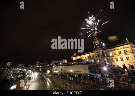 Dresda, Germania. 01st Jan 2022. Un razzo di Capodanno sale in aria sopra le case della storica città vecchia di Dresda e esplode. Nei luoghi pubblici, l'accensione di pirotecnici è proibita, quindi sono lanciati in strade laterali. Credit: Daniel Schäfer/dpa-Zentralbild/dpa/Alamy Live News Foto Stock