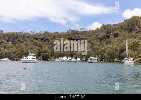 Rifugio Bay, Cowan Creek sul fiume Hawkesbury con barche a motore e yacht a vela ormeggiati su boe in Refuge Bay durante l'estate, Sydney, Australia Foto Stock