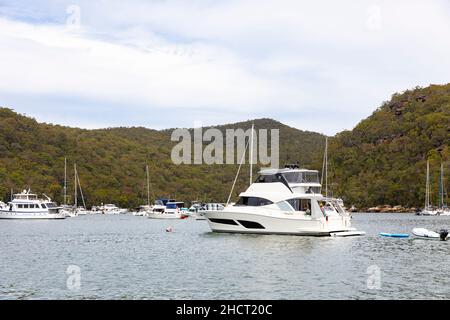 Rifugio Bay, Cowan Creek sul fiume Hawkesbury con barche a motore e yacht a vela ormeggiati su boe in Refuge Bay durante l'estate, Sydney, Australia Foto Stock