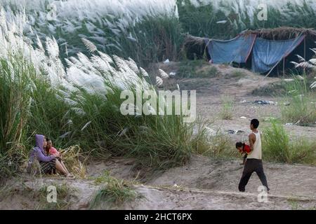 Maesot, Tailandia. 31st Dic 2021. Un uomo Karen che cammina verso una donna mentre porta un bambino al campeggio. Le persone Karen evacuate vivono in un campeggio temporaneo lungo il fiume Moei sul lato del Myanmar che può essere visto dal lato della Thailandia intorno al distretto di Mae Sot. Vivono qui da circa 3 settimane dopo il conflitto tra l'esercito del Myanmar e l'esercito KNU (Unione Nazionale di Karen) nello Stato di Karen del Myanmar. (Foto di Phobthum Yingpaiboonsuk/SOPA Images/Sipa USA) Credit: Sipa USA/Alamy Live News Foto Stock