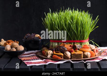 Novruz impostazione tavola decorazione, erba di grano, Azerbaijan nazionale pasticceria paklava, festa di nuovo anno squillante, risveglio della natura Foto Stock