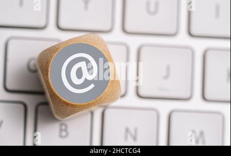 Invia un'e-mail all'icona su un cubo di legno su una tastiera. Immagine concettuale dei metodi di contatto e comunicazione Foto Stock