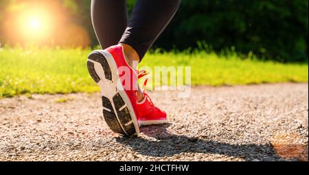 Scarpe running donna running in parco forestale in estate. Jogging ragazza esercizio motivazione calore e fitness. Foto Stock