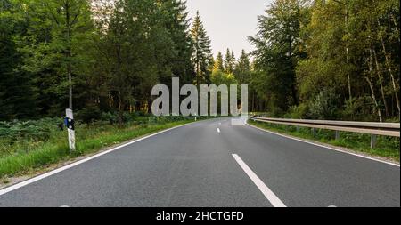 Lungo Curvy Forest Road in Alpine Mountains Foto Stock