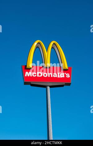 McDonald's Restauraunt segno in germania contro cielo blu. La McDonald's Corporation è la più grande catena al mondo di ristoranti fast food con hamburger. Foto Stock