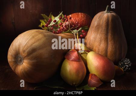 pere mature e zucca su sfondo di legno scuro in stile rustico Foto Stock