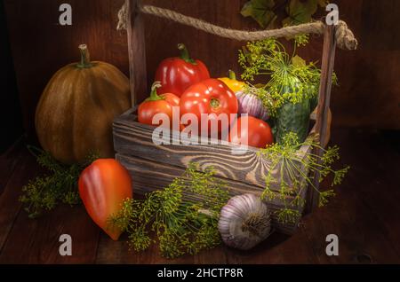 verdure fresche in una scatola su sfondo di legno scuro in uno stile rustico Foto Stock