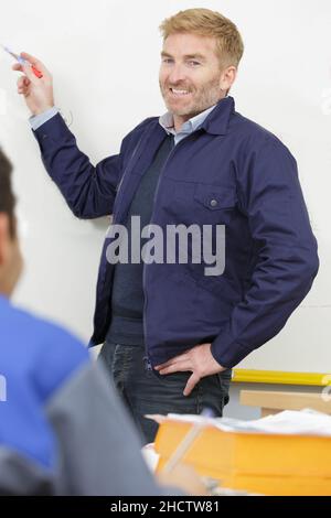un insegnante che scrive sulla lavagna Foto Stock