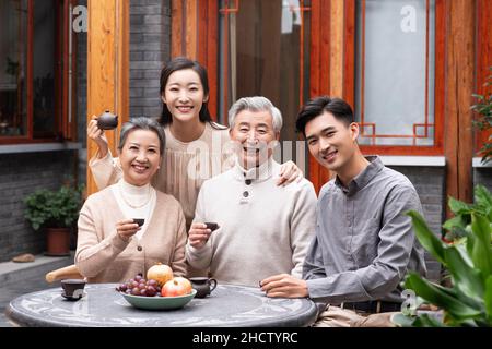 Famiglie felici che bevono il tè e chiacchierano nel cortile Foto Stock