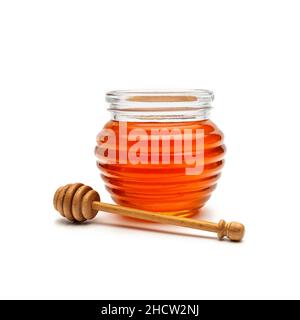 Bicchiere di miele in un vaso con un cucchiaia di miele di legno, isolato su sfondo bianco Foto Stock