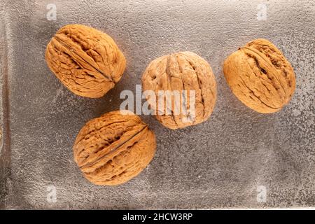 Diverse noci organiche su un vassoio di metallo, primo piano, vista dall'alto. Foto Stock