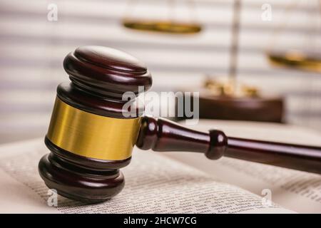 Primo piano di un libro di legge aperto con un gavel giudici con scala Foto Stock