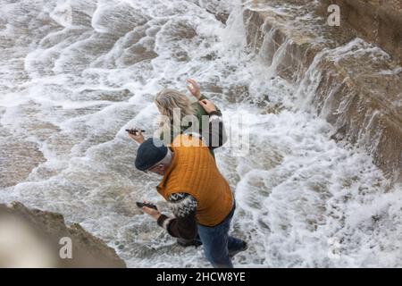 Portreath, Cornovaglia, 1st gennaio 2022, grandi onde e mari tempestosi a Portreath, Cornovaglia causata da forti venti Sud Westerly questa mattina. Due persone sono state catturate dalle onde come sono venuto sopra il muro del porto che li ha fatto correre via che si bagnatura nel processo.la temperatura era 13C che è mite per il periodo dell'anno. La previsione è di essere venti gustosi per oggi che si calmerà questa sera.Credit: Keith Larby/Alamy Live News Foto Stock