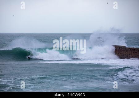 Portreath, Cornovaglia, 1st gennaio 2022, grandi onde e mari tempestosi a Portreath, Cornovaglia causata da forti venti Sud Westerly questa mattina. La gente era fuori a piedi e guardava le onde il giorno di Capodanno, sperando di avere un anno migliore di quello dell'anno scorso. La temperatura era di 13C che è mite per il periodo dell'anno. La previsione è di essere venti gustosi per oggi che si calmerà questa sera.Credit: Keith Larby/Alamy Live News Foto Stock