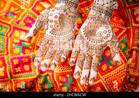 Le mani della donna o della sposa sono decorate in mehndi, una forma di arte del corpo e decorazione temporanea della pelle disegnata solitamente sulle mani o sulle gambe. Foto Stock