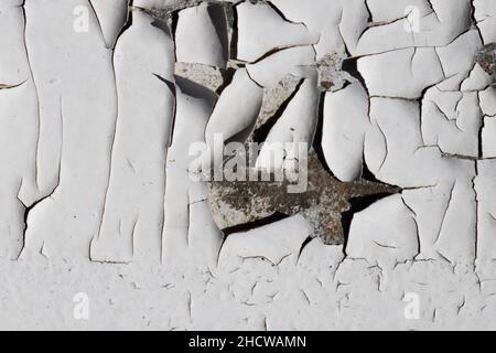 Grana bianca incrinata. Superficie danneggiata, invecchiata e danneggiata. Vecchia parete dipinta con crepa. Foto Stock