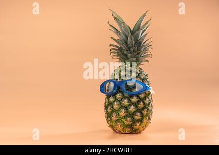 L'interpretazione della frutta di ananas in un'immagine umana con occhiali per il nuoto è un simbolo di turismo ricreazione e vacanze. Foto Stock