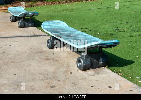 Vecchio panca blu simile a uno skateboard su ruote Foto Stock