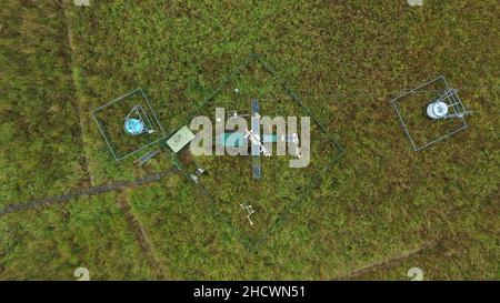 Stazione di ricerca per studiare le zone umide meadows ecosistema drone video aereo girato una stazione meteo palude con salici, ciclo e flusso di carbonio, eddy Foto Stock