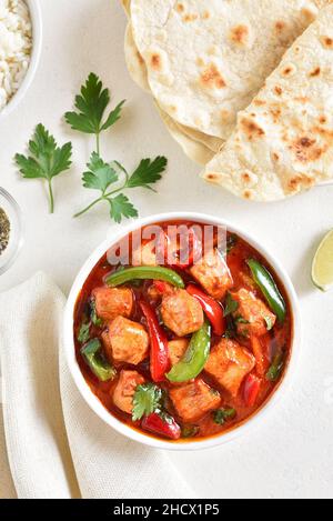 Curry di pollo rosso di stile thailandese in ciotola su sfondo di pietra bianca. Vista dall'alto, piatto Foto Stock