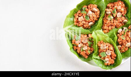 Tazzine di lattuga di carne tritata in stile thailandese su sfondo bianco con spazio copia. Vista dall'alto, piatto Foto Stock