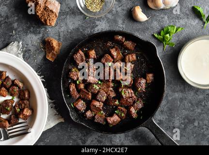 Un pezzo di carne alla griglia in una padella di ghisa con verdure, primo  piano Foto stock - Alamy