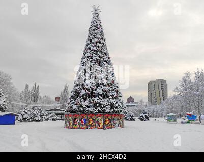 Albero di Natale innevato nel parco della città vecchia all'inizio di dicembre mattina Foto Stock