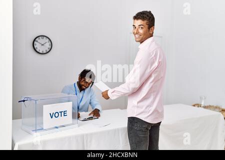 Due uomini sorridono fiduciosi di votare al collegio elettorale Foto Stock