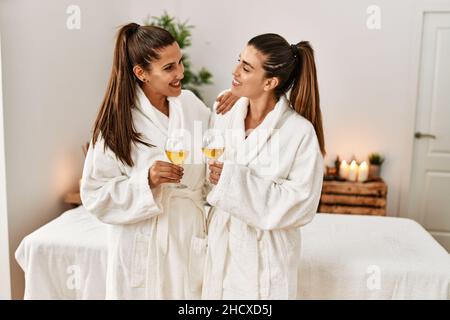 Due donne indossano accappatoio tostando con champagne in piedi al centro di bellezza Foto Stock