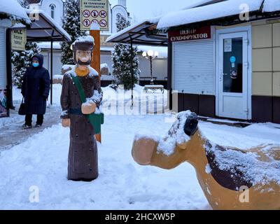 Una donna che indossa una maschera facciale cammina oltre le figure dei cartoni animati in un mercato non operativo durante il fine settimana di Capodanno.Voronezh previsioni ha dato una previsione per un lungo fine settimana di Capodanno. Questa volta, tranne l'inverno reale per durare tre giorni, la nevicata praticamente non si fermerà. I residenti della città trascorrono il fine settimana di Capodanno a piedi, facendo shopping, visitando cinema e parchi. Molte istituzioni operano con restrizioni antivirali. All'ingresso, le persone devono avere codici Quar che confermano la vaccinazione o la presenza di anticorpi. Altri stabilimenti sono completamente chiusi in holi Foto Stock