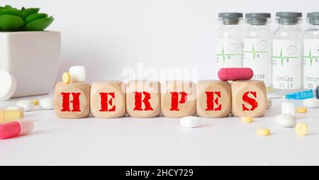 Herpes - parola da blocchi di legno con lettere, malattie virali di herpes virus concetto, sfondo blu. Foto Stock