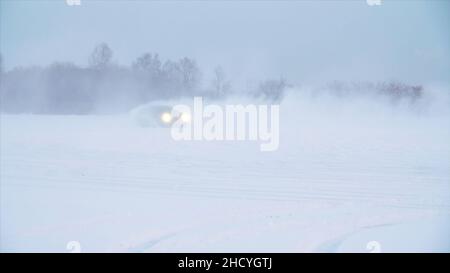 Strada nevosa in foresta con auto vicino e facendo un 180 giro slow motion . L'auto sta facendo una deriva nella neve. In inverno l'auto corre su una strada innevata. Foto Stock