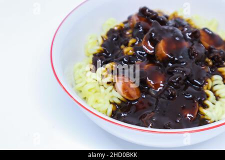 Un'immagine di dettaglio di gustoso Noodle coreano chiamato Jjajangmyeon con Lot of Sauses come un Topping in the White background Foto Stock