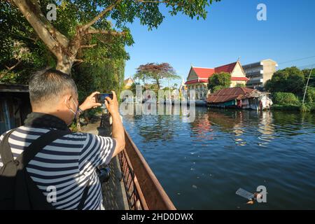 Un turista a Klong Bangkok Yai, un canale a Thonburi, Bangkok, Thailandia, Thonburi una volta la capitale del vecchio Siam, ora in parte ancora con un'atmosfera rurale Foto Stock