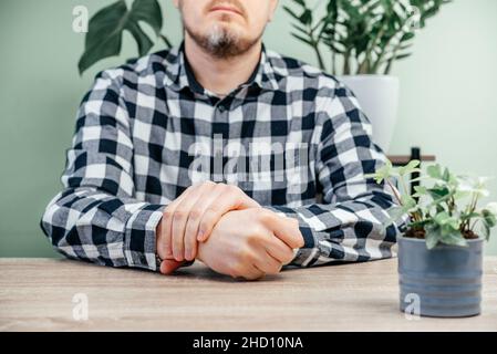 Un uomo che sente dolore in mano, artrite reumatoide e infiammazione delle articolazioni concetto Foto Stock