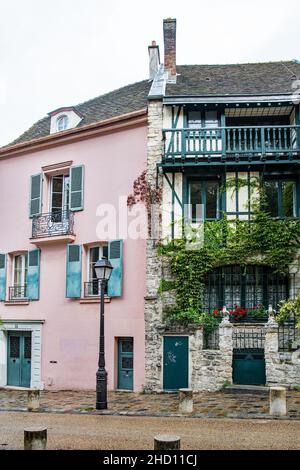 Una famosa casa rosa ed edifici a Montmartre, in una strada tipica Foto Stock