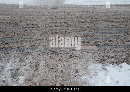 Cingoli ruote su fango. Neve su terreno sporco con cingoli ruote auto. Foto Stock