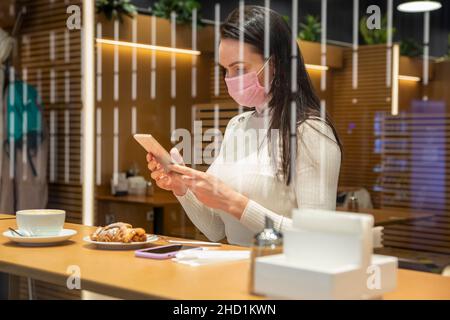 donna d'affari impegnata che lavora in una pausa pranzo in un caffè Foto Stock