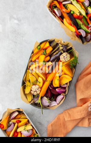 Verdure fresche tritate cucinate al forno in vari piatti di ceramica, vista dall'alto Foto Stock