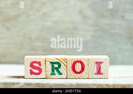 Lettera di alfabeto blocco in parola SROI (abbreviazione di Social Return on Investment) su legno sfondo Foto Stock