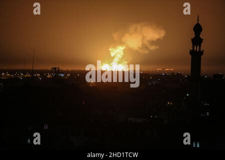 Una palla di fuoco e fumo sale durante gli attacchi aerei israeliani a Khan Yunis, nella striscia meridionale di Gaza, il 2 gennaio 2022. Foto Stock