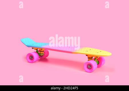 rainbow Plastic Penny skateboard isolato su sfondo rosa Foto Stock