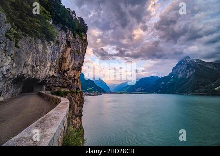 Tramonto sul lago di Lucerna, la città Flüelen in lontananza sulla riva del lago. Foto Stock